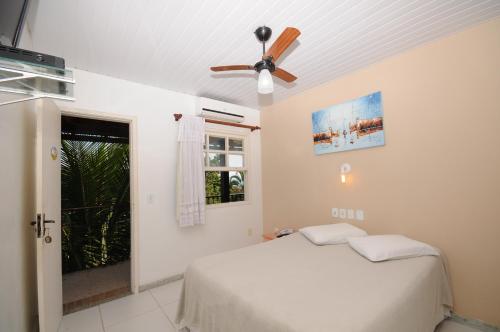 a bedroom with a bed and a ceiling fan at Pousada Areias Brancas in Búzios