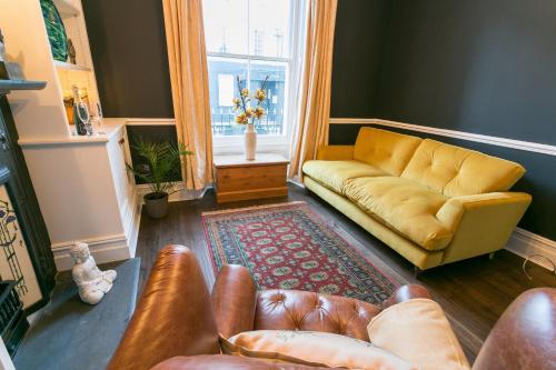 a living room with a couch and a window at Craig Hyfryd in Beaumaris
