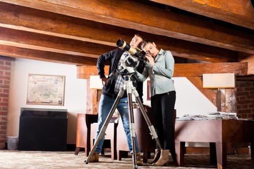 a man and a woman standing behind a camera at Hotel Krasicki in Lidzbark Warmiński