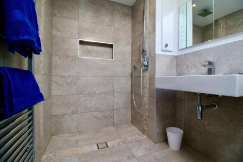 W łazience znajduje się prysznic, umywalka i wanna. w obiekcie Serenity "your calm seafront retreat" By Air Premier w mieście Seaford