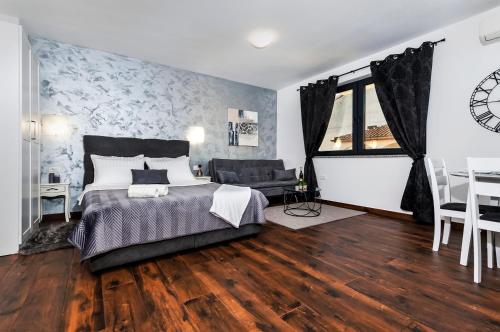 a bedroom with a large bed and a dining room at Deluxe Apartments A&A in Rovinj