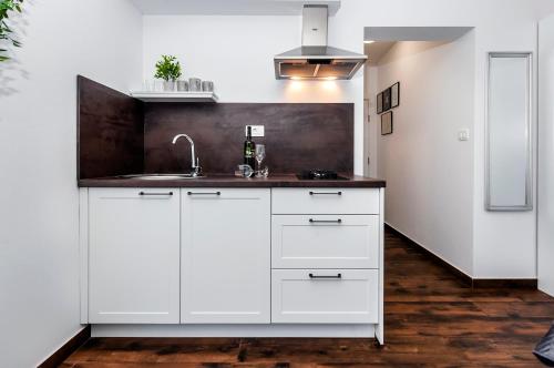 a kitchen with white cabinets and a sink at Deluxe Apartments A&A in Rovinj