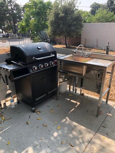 a grill sitting next to a table with a sink at Clearlake Cabins in Clearlake