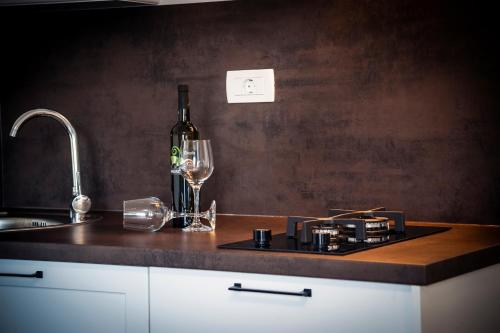 a kitchen counter with a bottle of wine and a glass at Deluxe Apartments A&A in Rovinj