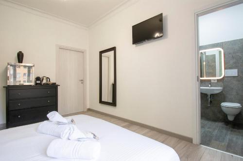 Luxury Boutique Hotel في روما: غرفة نوم بسرير أبيض مع حوض ومرآة