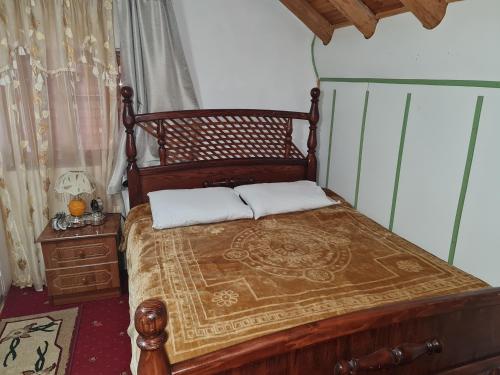 a bed with two pillows on it in a room at Sofra Kolonjare Agroturizem in Ersekë