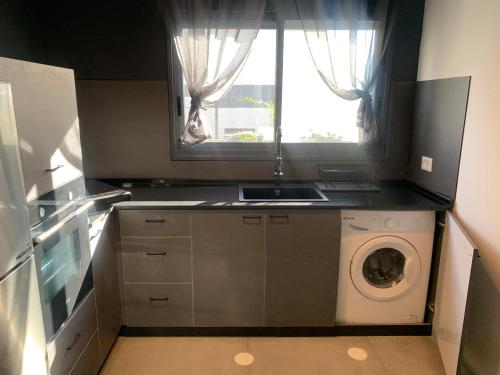 a kitchen with a washing machine and a window at Via Arad Apartments in Arad