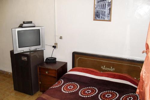 ein Schlafzimmer mit einem Bett und einem TV auf einem Tisch in der Unterkunft Hotel Zaragoza in Puebla