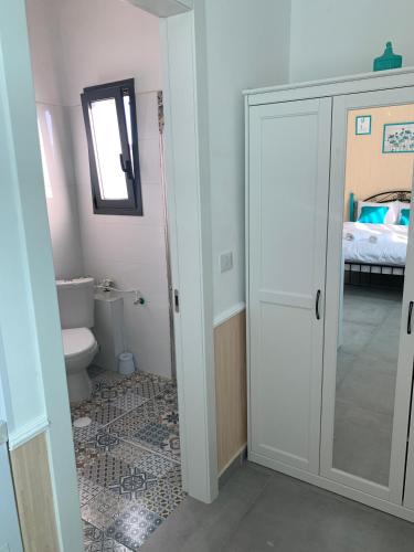 a bathroom with a toilet and a glass door at Via Arad Apartments in Arad