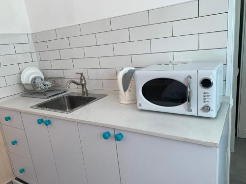 a microwave sitting on a kitchen counter next to a sink at Via Arad Apartments in Arad