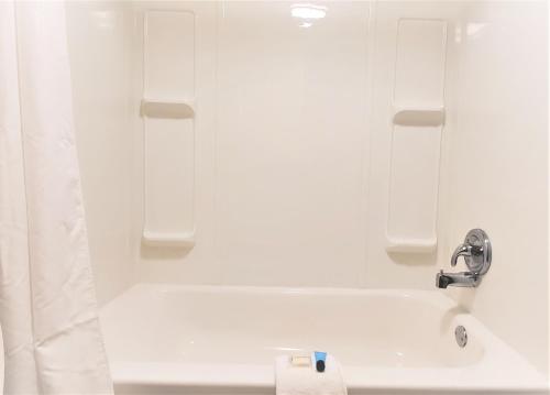 La salle de bains blanche est pourvue d'une baignoire et d'un lavabo. dans l'établissement Economy 7 Inn- Newport News, à Newport News
