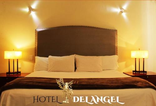 a hotel bedroom with a large bed with two lamps at Hotel del Angel in Guadalajara