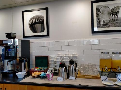 a counter top with a coffee maker and drinks on it at Ventura Inn & Suites Hamilton in Hamilton