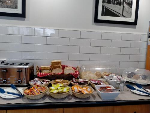 a counter with bowls of food and baskets of food at Ventura Inn & Suites Hamilton in Hamilton