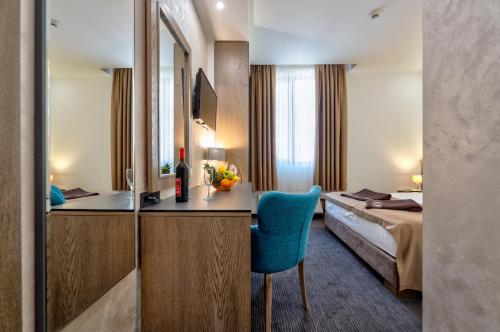 a hotel room with a bed and a blue chair at CentRoom Gold in Zlatibor