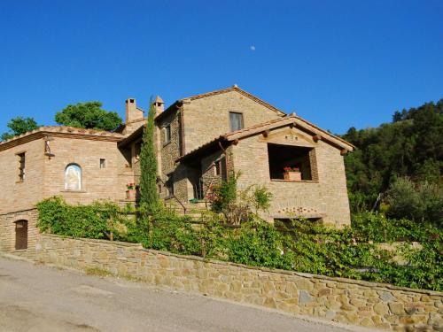una vieja casa de ladrillo en una pared de piedra en Belvilla by OYO Casa Lamate en Cortona