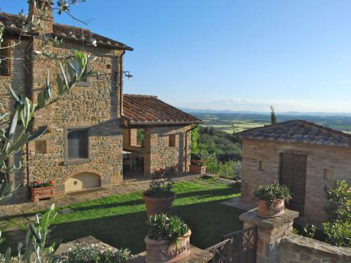 uma vista exterior de uma casa de pedra com vasos de plantas em Belvilla by OYO Casa Lamate em Cortona