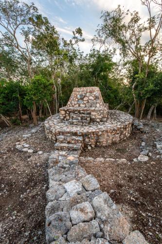 an old stone structure in front of some trees at Xuux Peek by Tecnohotel in Yaxché