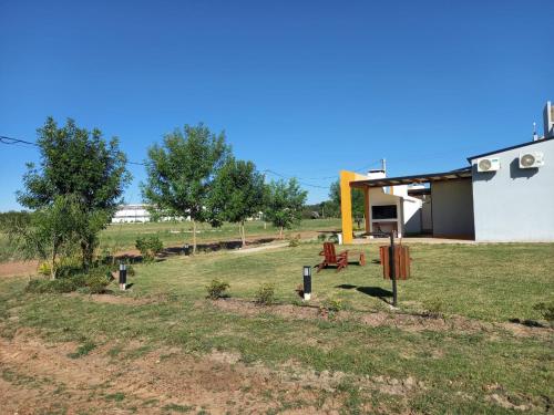 a house in a field next to a building at SUEÑOS DE TERMAS in Chajarí