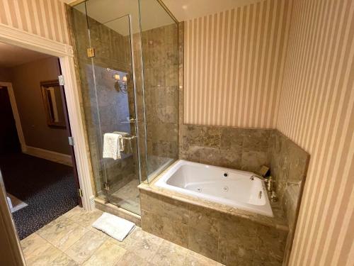 a large bathroom with a tub and a shower at Celebrity Boutique Hotel in Deadwood
