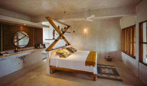 a bedroom with a bed and a mirror and a sink at Hotel Pocna Tulum in Tulum