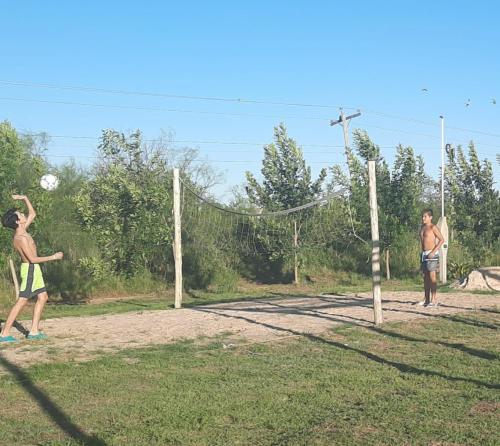 two young men playing a game of frisbee at SUEÑOS DE TERMAS in Chajarí