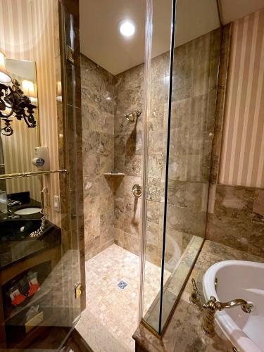 a bathroom with a shower and a tub and a sink at Celebrity Boutique Hotel in Deadwood