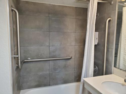 a bathroom with a shower and a tub and a sink at Relax Inn West Medical Center in Little Rock