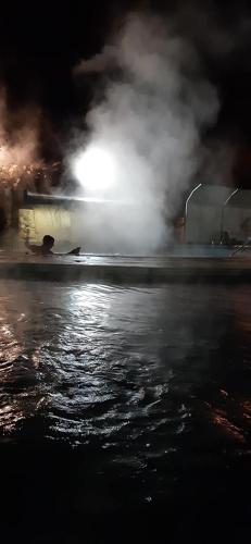a body of water at night with smoke and fire at SUEÑOS DE TERMAS in Chajarí