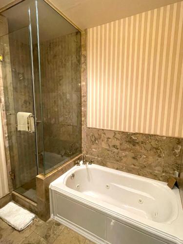 a bathroom with a tub and a glass shower at Celebrity Boutique Hotel in Deadwood