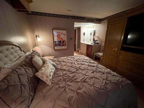 a bedroom with a large bed and a bathroom at Celebrity Boutique Hotel in Deadwood