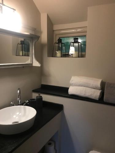 a bathroom with a white sink and a mirror at Street Farmhouse in Godshill