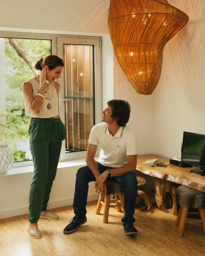 a woman standing next to a man sitting on a stool at Sete Cidades Lake Lodge in Sete Cidades