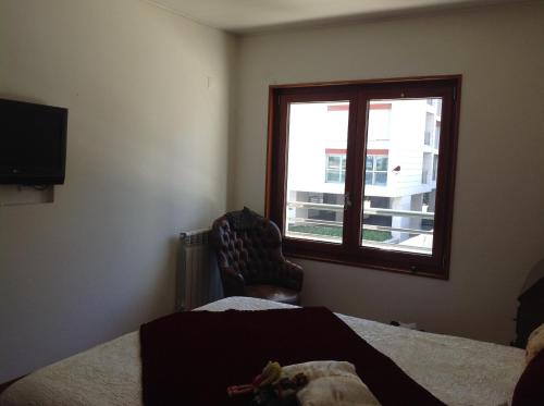 um quarto com uma cama, uma janela e uma cadeira em Canas Guest House in Lisbon (AL) em Lisboa