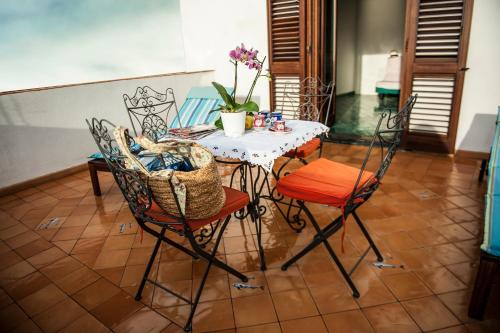 uma mesa de jantar com cadeiras e uma mesa com flores em Tenuta Mamma Carmela em Amalfi