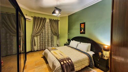 a bedroom with a bed and green walls at Oranger Family House - Marrakech in Marrakech