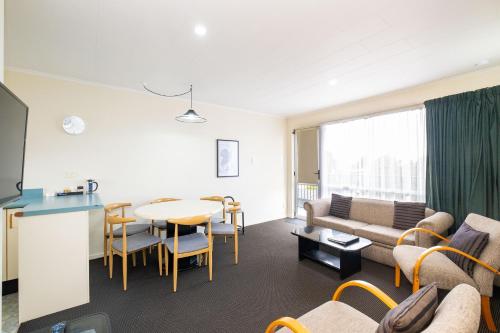 a living room with a couch and a table at Chevron Motel in Taupo