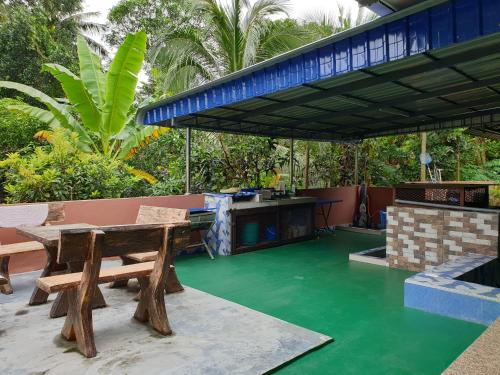 an outdoor patio with a table and a grill at Inapdesa Teratak Bonda, Sepri REMBAU in Rembau