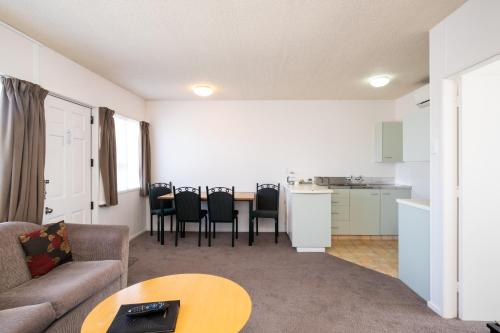 a living room with a couch and a table at Chevron Motel in Taupo