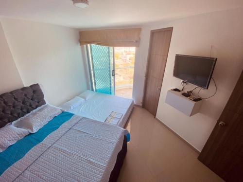 1 dormitorio con 1 cama y TV de pantalla plana en Edificio Aragoa, Rodadero sur, santa Marta, en Santa Marta