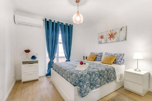 a white bedroom with a bed and a window at Cascais Lindo in Cascais