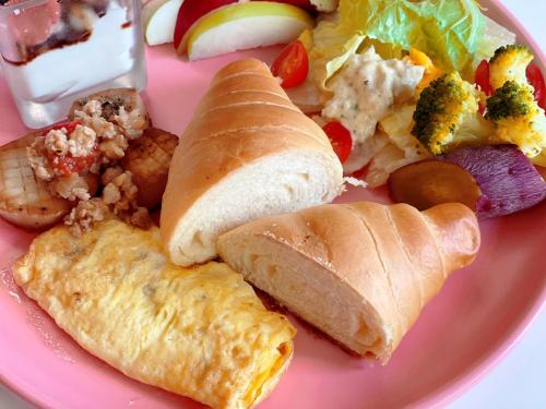 a pink plate of food with bread and vegetables at Square B&B in Taitung City