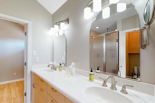 Un baño con dos lavabos y un espejo grande. en Little House on the Bay, en Galveston