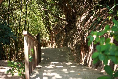 a wooden path with trees and a fence at Hotel Casablanca in Pipa