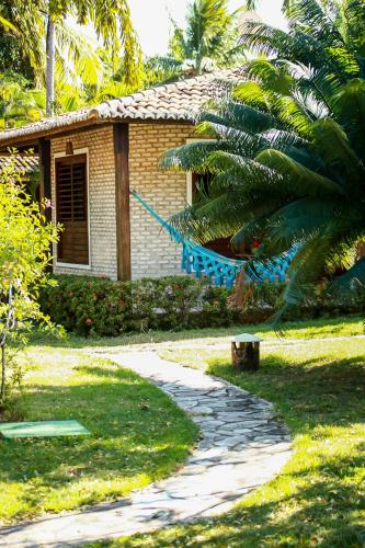 a house with a hammock in front of a garden at Hotel Casablanca in Pipa
