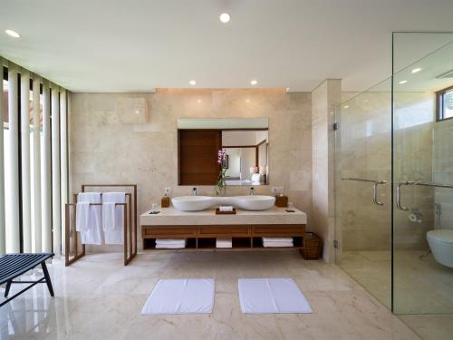 a bathroom with a tub and a shower and a sink at Villa Kailasha by Elite Havens in Tanah Lot