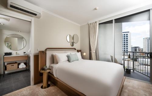 a bedroom with a white bed and a large window at Mantra Terrace Brisbane in Brisbane
