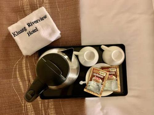 a tray with a cup and a tea pot and some food at KLUANG RIVERVIEW HOTEL in Kluang