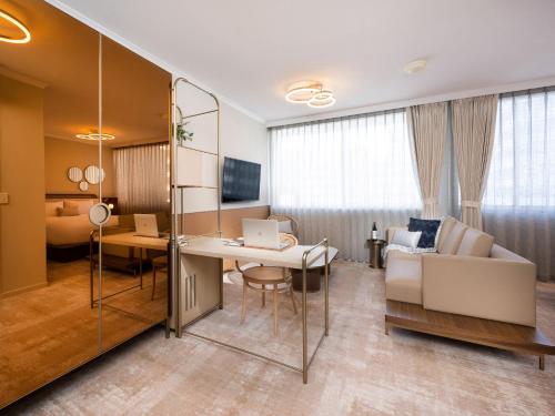 a hotel room with a desk and a couch at Mantra Terrace Brisbane in Brisbane