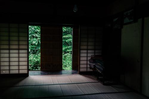 an open door to a room with a window at Kamiya Rare Experience in a 180 Year Old Farmhouse Milky Way Irori Fire and Nature! in Iida